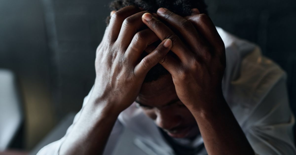 A man is holding his head in his hands